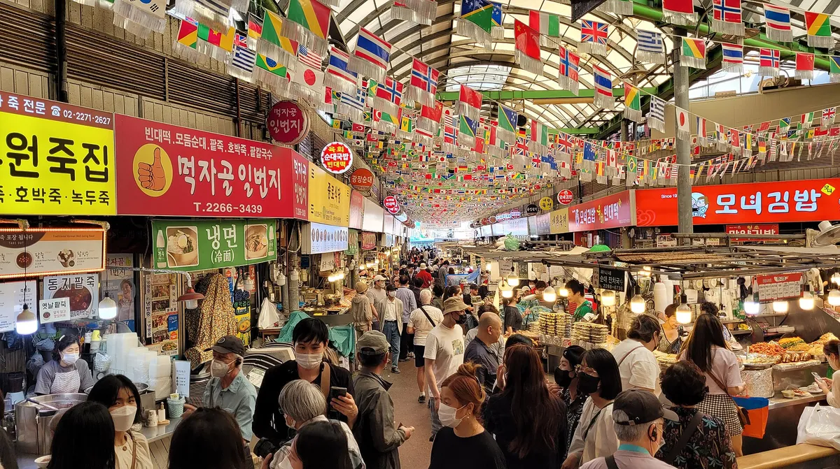 Crowds walking through the busy food alleys of Gwangjang Market in Seoul