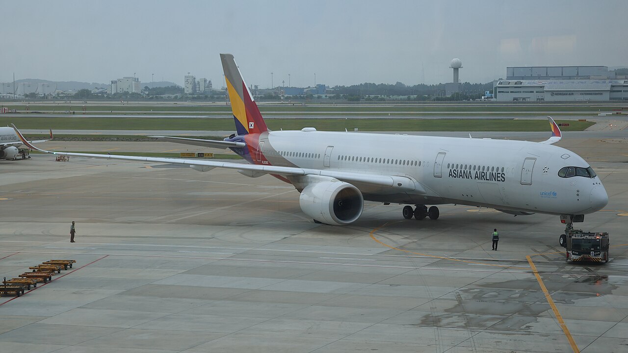 White Asiana Airlines Airbus A350 with a multicoloured tail parked on the apron at Incheon Airport under an overcast sky